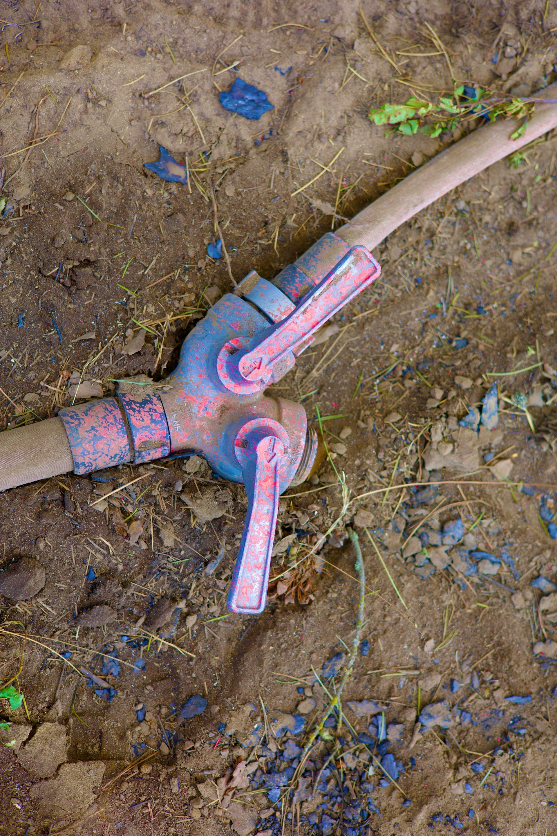 A water hose connector is shown on the ground.